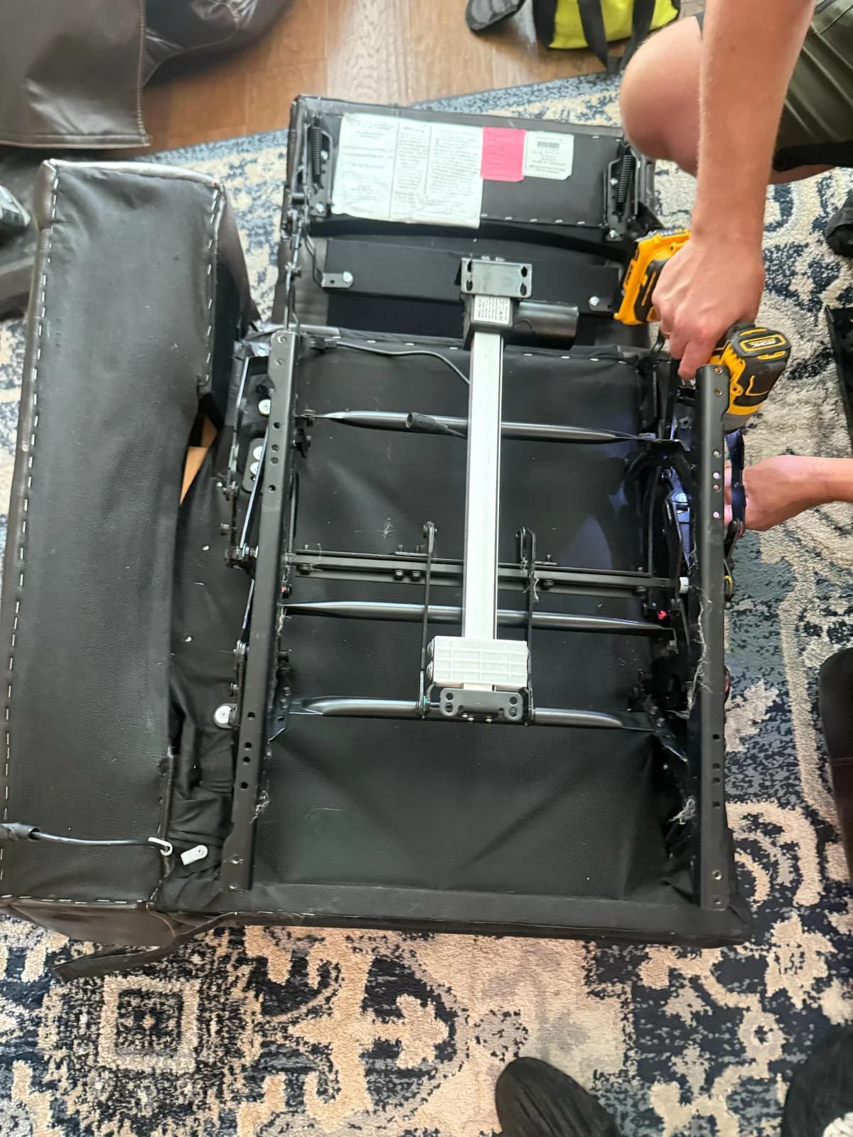 Underside of a recliner with the metal frame and actuator exposed