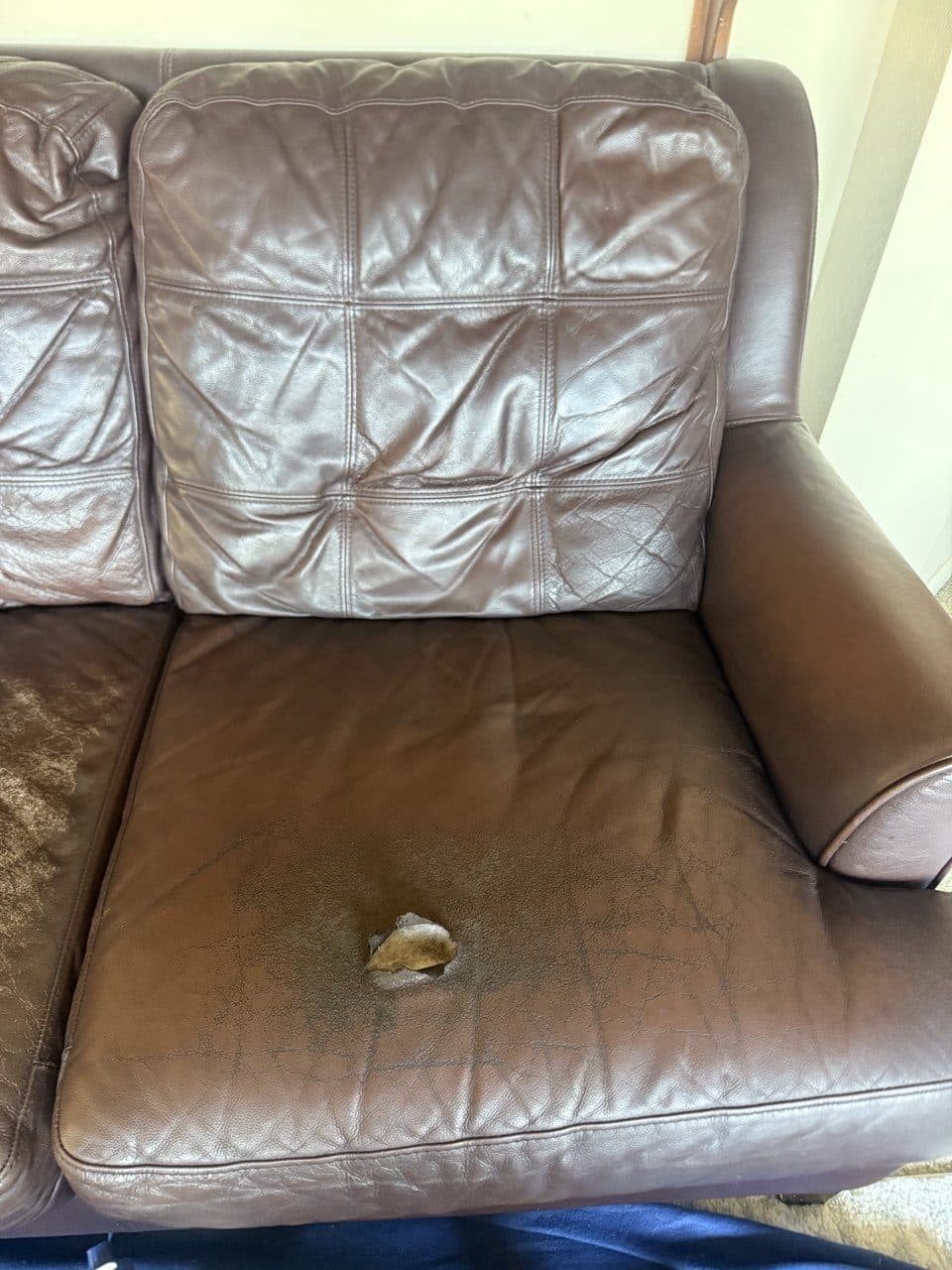 Brown Leather Sofa Seat With A Large Hole, Cracking, And Heavy Wear
